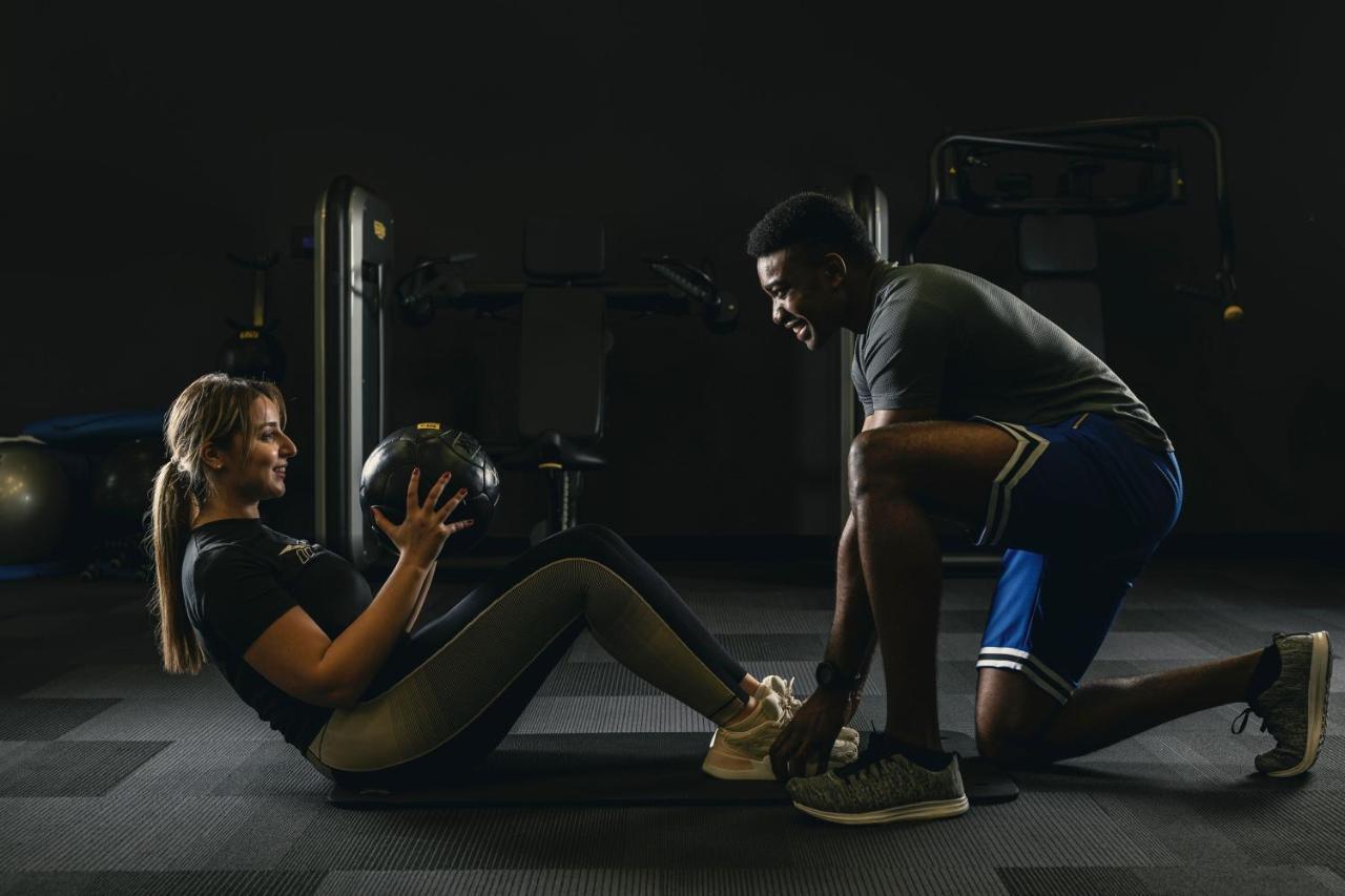 多哈威斯汀酒店 外观 照片 Personal trainer assisting a woman with a sit-up